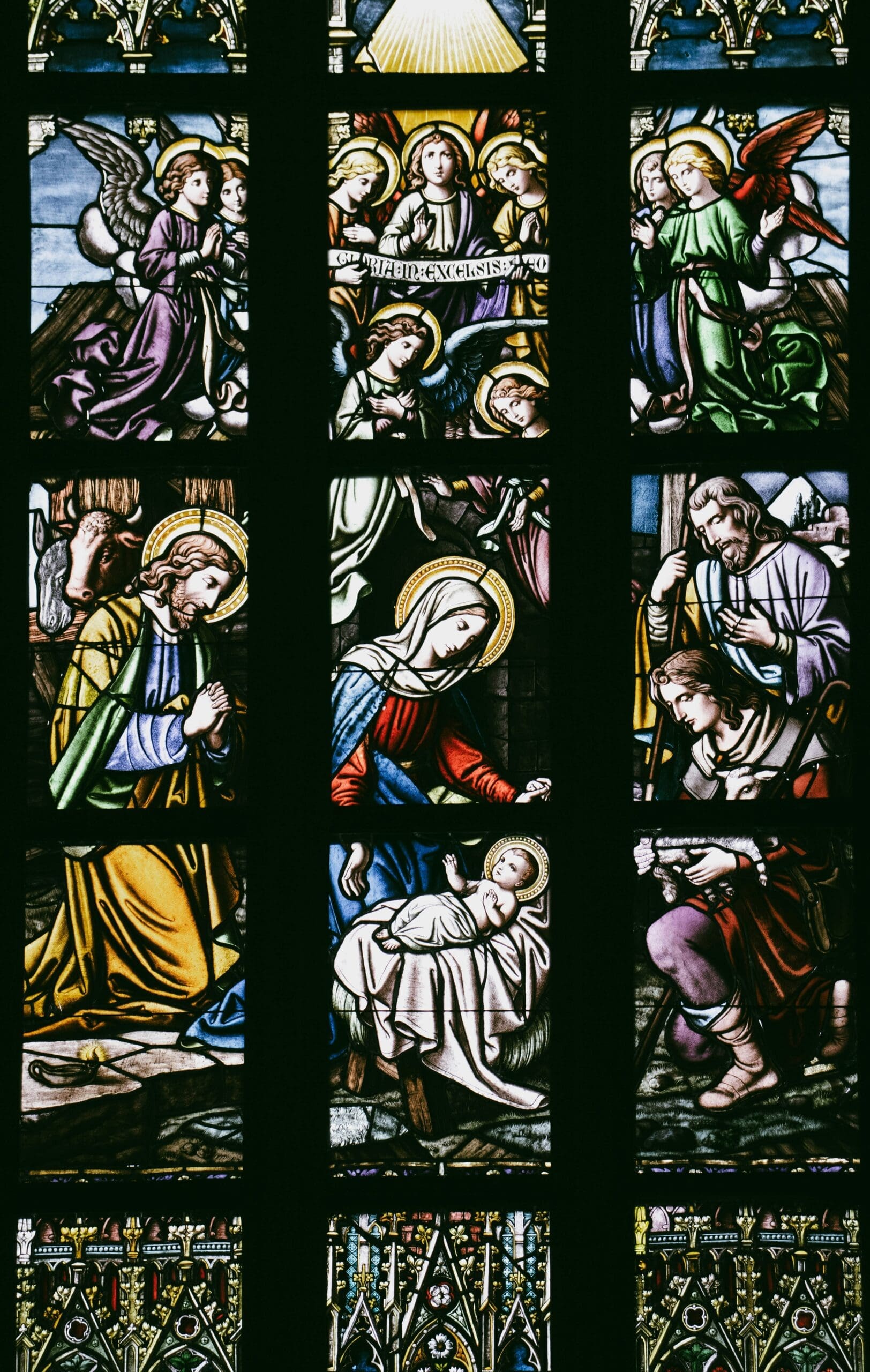 A detailed stained-glass window featuring colorful depictions of biblical scenes